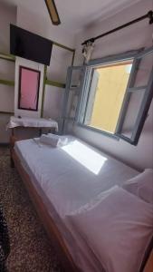 a small bedroom with a bed and a window at Old town Room With Window in Rethymno