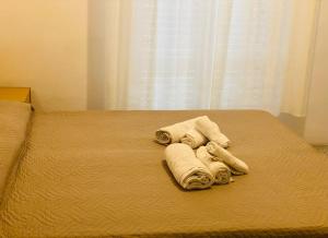 una pila de toallas en una cama con ventana en hotel iris, en Rímini