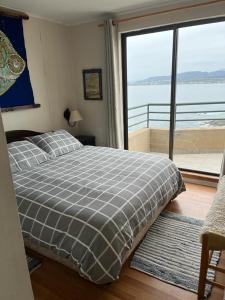 a bedroom with a bed and a large window at Horcon Condominio CAUCAU in Horcón