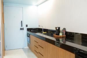 a kitchen with a black counter top and a sink at Shopping Piratas, vista para o mar, estacionamento in Angra dos Reis +39 photos