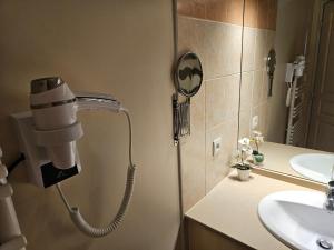 a bathroom with a blow dryer on the wall next to a sink at Nouveau Entre mer et ville in Lattes