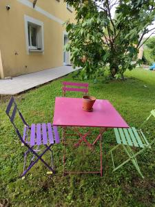 a pink table with two chairs and a pot on it at Maison 115 m 2 avec Jardin in Carignan