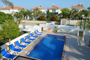 an overhead view of a swimming pool with blue lounge chairs at Ayia Napa Marina Luxury Villas - Diamond in Ayia Napa