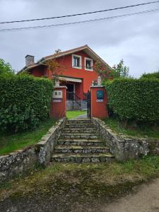 a red house with stairs in front of it at El Tayo in Cudillero