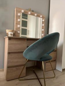 einen Stuhl vor einer Kommode mit einem Spiegel in der Unterkunft Apartament u Buni in Breslau