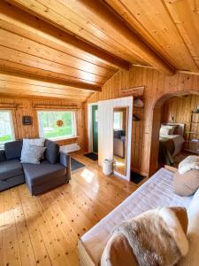 a room with a bed and a couch in a cabin at Laplandliv cabin on the lake with hottub in Björkliden +31 photos