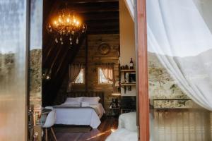 a bedroom with a bed and a chandelier at Estância Nazari in Urubici +113 photos