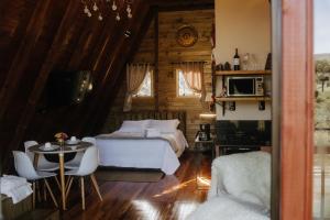 a bedroom with a bed and a table in a room at Estância Nazari in Urubici