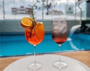 两兄弟镇FIKA Residence的坐在泳池旁的桌子上,喝上两杯鸡尾酒