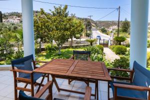 a table and chairs on a porch with a view of a street at Apricus1 in Apolpaina