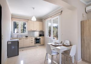 a kitchen with a white table and white chairs at Apricus1 in Apolpaina