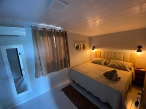a bedroom with a bed with a teddy bear on it at Pousada Casa Berna in Fernando de Noronha +141 photos