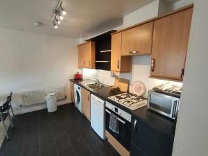 eine Küche mit Holzschränken und einer schwarzen Arbeitsplatte in der Unterkunft Landau House in Bristol