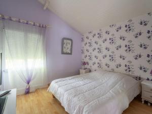 a bedroom with a bed with a floral wallpaper at Maison Charmante 3* à Mimizan: Plages, Pistes Cyclables, Jardin, Wi-Fi, pour 8 Personnes - FR-1-50-137 in Mimizan