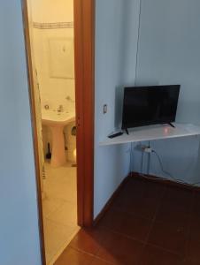 a bathroom with a television on a shelf in a room at Alojamento Local, Cantinho Verde in Corroios +37 photos