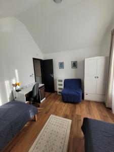 a bedroom with a bed and a desk and a blue chair at J2Velence Apartman in Velence +71 photos