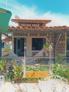 een huis met een hangmat in de voortuin bij Villa das Pedras - Ponta de Pedras in Goiana