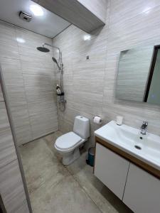 a bathroom with a toilet and a sink at Cottages - Townhouses in Ureki +24 photos