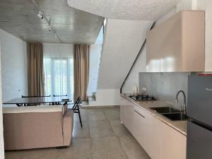 a kitchen with a sink and a table in it at Cottages - Townhouses in Ureki