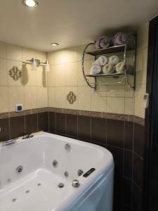 ein Badezimmer mit Badewanne und einem Regal mit Handtüchern in der Unterkunft Old Wine House in Klaipėda