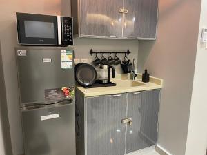 een kleine keuken met een spoelbak en een magnetron bij A Chill Modern Apartment in Riyad
