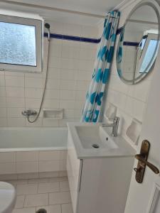 a bathroom with a sink and a tub and a shower at Deco Apartments Aigina in Vaia +26 photos