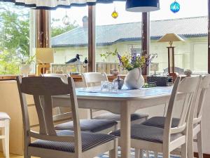 a dining room table with chairs and a large window at 4 person holiday home in FALKENBERG-By Traum in Falkenberg