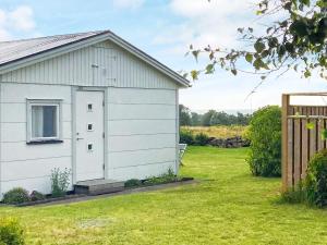 a white building in a yard with a fence at 4 person holiday home in FALKENBERG-By Traum in Falkenberg