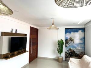 a living room with a flat screen tv on a wall at Apartamento Tulum in Barra Grande