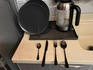 een aanrecht met vorken en lepels op een plank bij A Chill Modern Apartment in Riyad +7 foto's