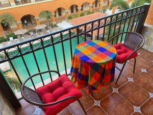 een tafel en stoelen met een kleurrijke deken op een balkon bij Marina Park Plaza Sol in Santa Cruz Huatulco
