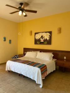 een slaapkamer met een bed en een plafondventilator bij Marina Park Plaza Sol in Santa Cruz Huatulco
