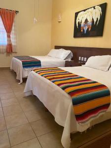 een hotelkamer met 2 bedden en een schilderij aan de muur bij Marina Park Plaza Sol in Santa Cruz Huatulco