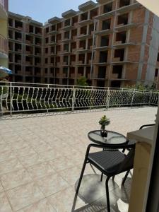 a patio with a table and a chair and a building at Апартамент Александър in Sunny Beach