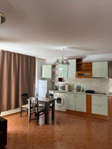 a kitchen with a table and chairs in a room at Апартамент Александър in Sunny Beach