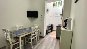 a room with a table and chairs and a television at Sicily Casa Vacanze in Cassibile