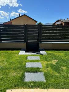 a bench sitting on the grass in front of a fence at Wooden Lodge in Osséja