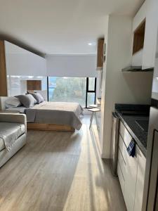 a bedroom with a bed and a large window at DF Acogedor Loft con Gym D02 in Bogotá +4 photos