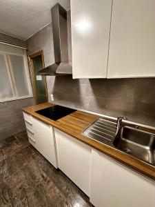 a kitchen with white cabinets and a sink at Céntrico Apartamento en Benidorm in Benidorm +8 photos