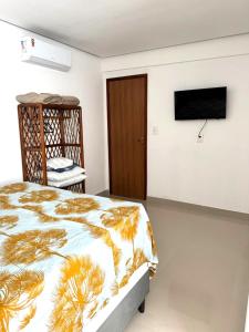 a bedroom with a bed and a flat screen tv at Apartamento Tulum in Barra Grande