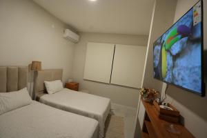 ein kleines Zimmer mit zwei Betten und einem Flachbildfernseher in der Unterkunft Little House Para 3 Personas - Casa compartida in Santa Cruz de la Sierra