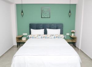 a bedroom with a large bed with a blue wall at Alexandra Comfort Apartments in Keramotí