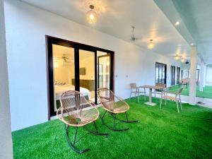 乌库拉斯La Palma Suites的绿草间里两把椅子和一张桌子