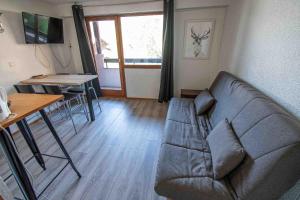 a living room with a couch and a table at Les Cimes, Chaleureux studio 4 pers, 50m du télécabine, vue dégagée sur les pistes, DRAPS NON COMPRIS in Saint-Jean-dʼAulps +11 photos