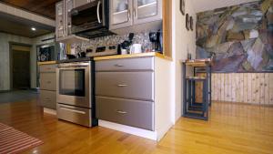 a kitchen with stainless steel appliances and a stone wall at Ozarks Luxurious Lakeside Villa at Harrison Lake in Harrison Hot Springs