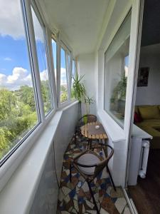 a small room with a table and two windows at R&J Apartment I in Panevėžys +7 photos