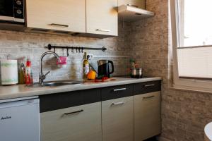 a kitchen with wooden cabinets and a sink at Apartamenty Wakacyjne WICJAN in Chałupy