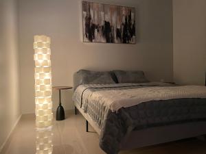 een slaapkamer met een bed en een lichtmast ernaast bij A Chill Modern Apartment in Riyad