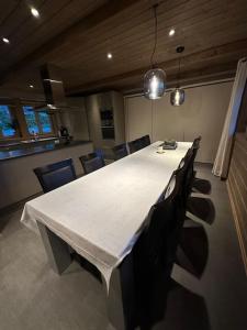 a long white table in a room with chairs at Myrkdalen Lodge II, luxury family cabin ski in and out in Helgatun