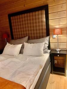 a bed with white sheets and pillows in a room at Myrkdalen Lodge II, luxury family cabin ski in and out in Helgatun +17 photos
